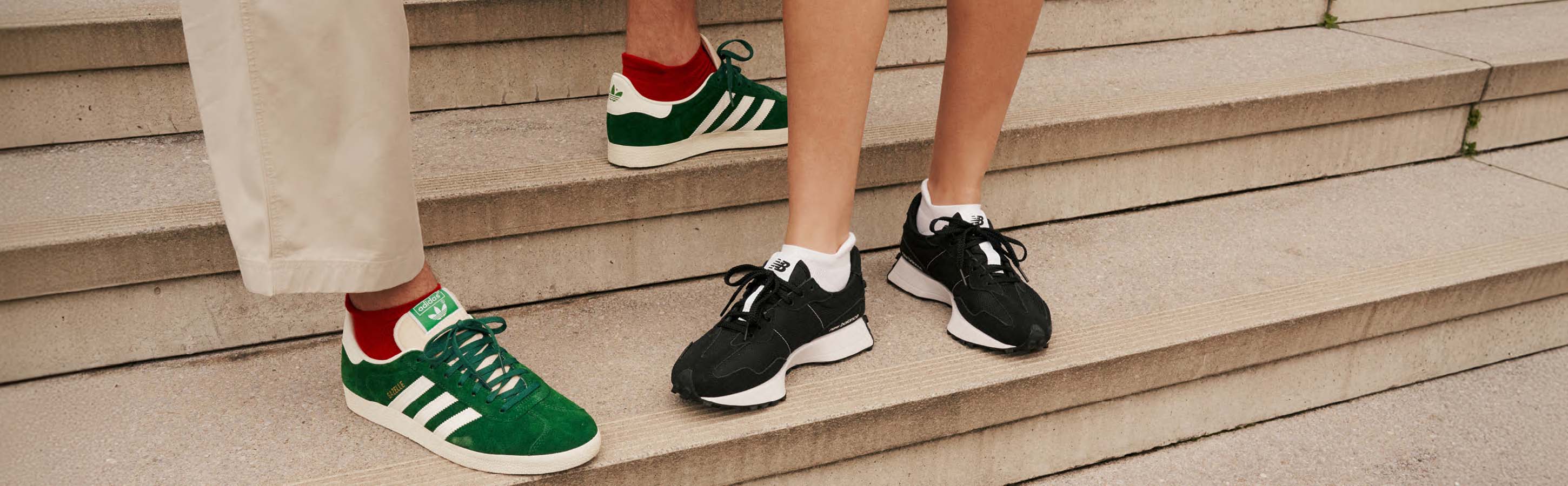 Nahaufnahme von Herren und Damenfüßen in Sneakern mit farbenfrohen Cool Kick Sneakersocken